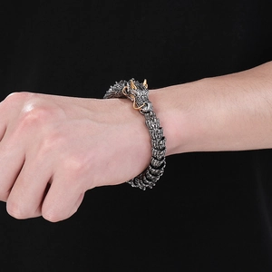 Detailed close-up of dragon bracelet showing intricate silver scales and gold horns on wrist