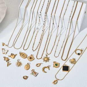 Golden stainless steel necklace chains and assorted charms set on a white background