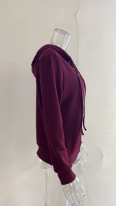 Dettaglio felpa con cappuccio in maglia a coste bordeaux con strisce e coulisse