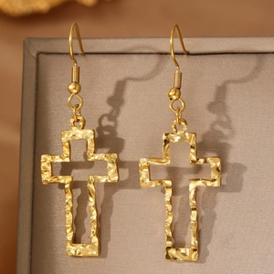 Detail of gold hollow cross earrings featuring a vintage hammered metal texture finish