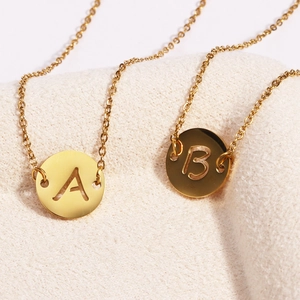 Colliers en acier inoxydable doré avec pendentifs lettres A et B sur tissu beige doux