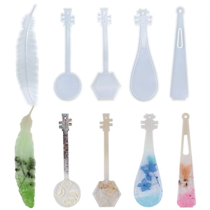 Détail des moules en silicone plume et guitare avec exemples de marque-pages en résine