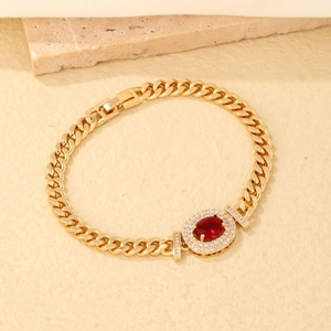 Elegant gold link bracelet with a red oval gemstone surrounded by sparkling zircon accents