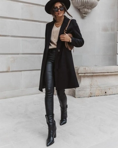 Street style view of mid-length black wool coat with leather pants and pointed boots