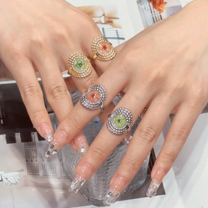 Vintage hollow stainless steel rings with colorful four-leaf clover patterns on a model's hand