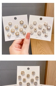Macro detail of assorted pearl and crystal collar pins on a white display card
