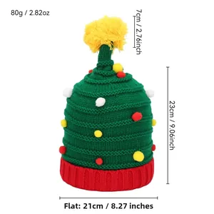 Groene en rode kerstgebreide muts met gele pompons en feestelijke beldecoraties