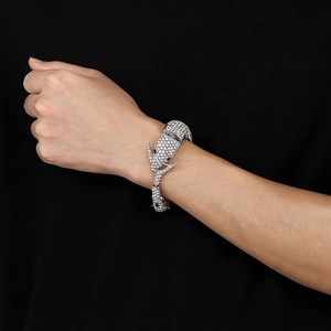 Détail macro du bracelet dauphin argenté serti de pierres brillantes au style punk