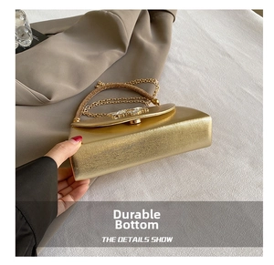 Detail shot of the durable wear-resistant base of this elegant gold evening clutch bag