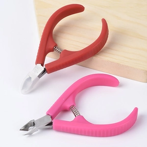 Detail of red and pink stainless steel tweezers and cuticle nippers with spring tension
