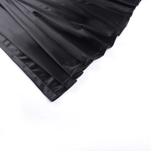Vue détaillée du tissu en satin noir élégant avec des plis fins et une fente haute