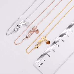 Detailed view of LOVE letter pendant with heart charm in silver, gold, and rose gold
