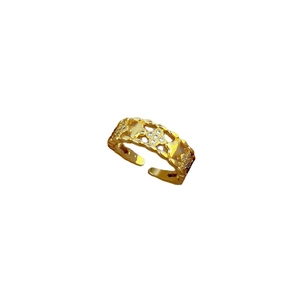 Adjustable golden flower ring with hollow petals and small crystal stones on white background