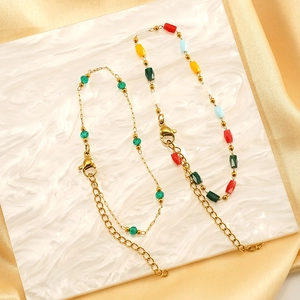Chic gold titanium steel bracelet with colorful glass beads and pearls on silk background