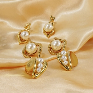 Parure de boucles d'oreilles dorées et perles aux designs géométriques sur soie dorée
