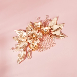 Close-up of golden bridal hair comb with metallic flowers, leaves, and crystal beads