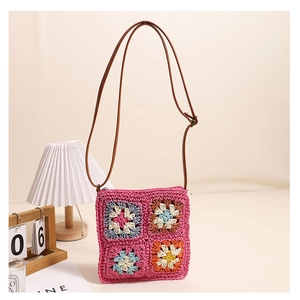 Detail of pink crochet granny square crossbody bag with floral patterns and leather strap