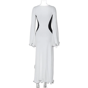 Détail d'une robe maxi blanche avec panneaux noirs et bords ondulés à volants