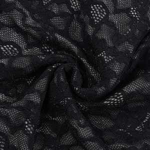 Close-up detail of sexy black lace jumpsuit showing intricate floral mesh and soft texture