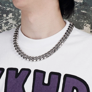 Close-up of 15mm silver Cuban link chain necklace with polished metal rings on neck
