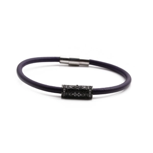 Detail of dark purple braided leather bracelet with black zircon charms and silver magnetic clasp