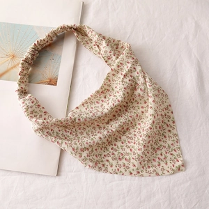 Detail view of floral chiffon headscarf with elastic band on minimalist background