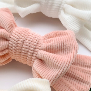 Pink and white corduroy bow headbands for babies with soft textured vertical stripes