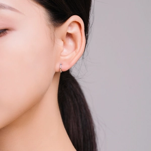 Créoles minimalistes en argent S925 avec zircons colorés portées par un mannequin