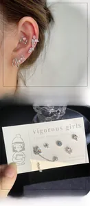 Detailed view of silver stud earrings set featuring pink zircon flowers and moon pendants
