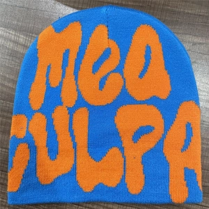 Detailed knit texture of blue MEA CULPA beanie with orange lettering on wood background