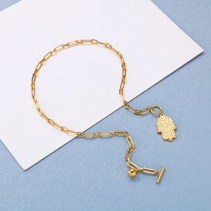 Detail of gold paperclip chain necklace with Hand of Fatima pendant and OT toggle clasp