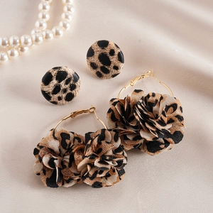 Two-piece leopard print fabric flower and round stud earrings set on silk background