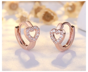 Macro detail of rose gold heart earrings featuring shimmering pavé cubic zirconia