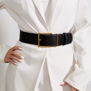 Cintura larga vintage in pelle nera con fibbia rettangolare dorata su blazer bianco