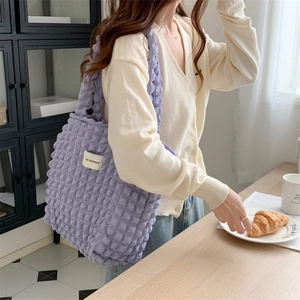 Detail of purple cloud bubble texture on shoulder bag in a cozy cafe setting