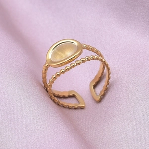 Detail of a vintage double-layer gold ring with oval gemstone on purple silk background
