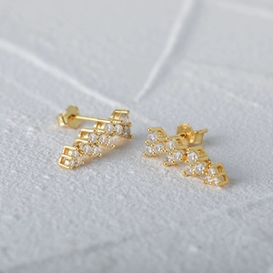 Close-up of gold-plated S925 silver wave earrings with sparkling pavé diamonds