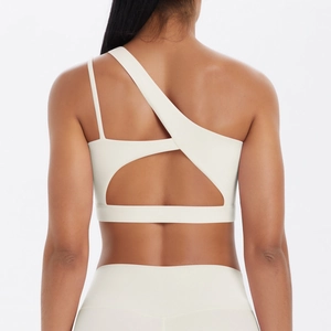 Detail of white sports bra featuring a unique one-shoulder strap and cutout back design