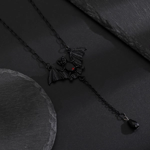 Macro shot of Gothic bat pendant featuring red ruby eyes and a black teardrop bead