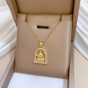 Gros plan d'un collier Vierge Marie doré avec cristaux brillants dans un coffret cadeau