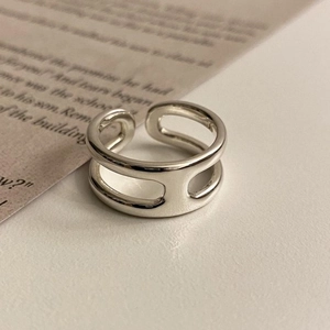 Minimalist double-layered sterling silver H-shaped open ring on a magazine page