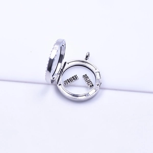 Detailed view of an open silver floating locket with metal 'BELIEVE' letter charms inside