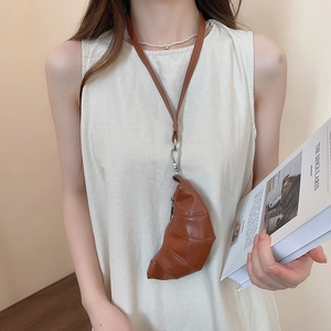 Sac bandoulière marron en forme de croissant en similicuir porté comme collier créatif