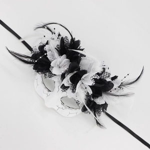 Close-up of Day of the Dead masquerade mask with black and white feathers and lace details