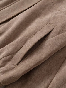 Detailaufnahme der Nähte an einer braunen Wildlederjacke mit weicher Stoffstruktur