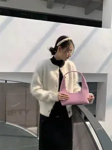 Close-up of pink crescent hobo bag with smooth leather texture and minimalist design