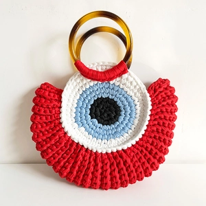 Handmade crochet evil eye handbag with red and blue yarn and resin ring handles