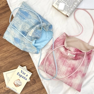 Close-up of tie-dye lace tote bags in blue and pink with geometric ethnic patterns