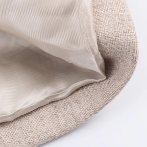 Dettaglio macro del tessuto in misto lana beige e fodera in raso di seta sul cappotto