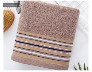 Close-up of soft grey cotton towel with parallel blue stripes and dense loops